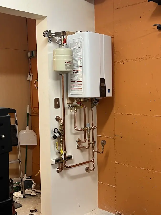 Plumbing technician inspecting water heater connections in Yelm